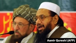 FILE: Hafiz Saeed (R), the founder of Lashkar-e-Taiba, talks journalists in Rawalpindi in 2012.