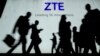 People walk in front of the ZTE stand at the Mobile World Congress (MWC), the world's biggest mobile fair, on February 27, 2018 in Barcelona.