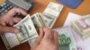 Dollars, euros and Iranian currency as a trader counts money. Undated