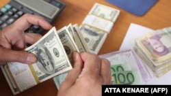 Dollars, euros and Iranian currency as a trader counts money. Undated