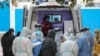 A medical staff member checks information as patients infected by the COVID-19 coronavirus leave from Wuhan No.3 Hospital to Huoshenshan Hospital in China's central Hubei province on March 4, 2020.