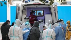 A medical staff member checks information as patients infected by the coronavirus leave Wuhan's No.3 Hospital.