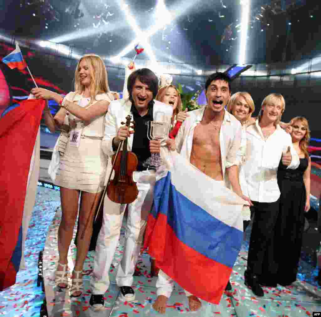Russian singer Dima Bilan wins Eurovision Song Contest - Dima Bilan (4th R with flag), flanked by Hungarian violinist Edvin Marton (2nd L) and Olympic figure skating champion Yevgeny Plushenko (2nd R) of Russia, celebrates after winning the Eurovision Song Contest 2008 at Belgrade Arena early on May 25, 2008. 