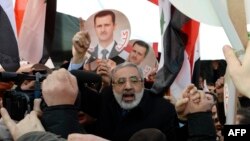 Сирия оппозициясы Женевадагы жыйынга Башар Асаддын сүрөтүн көтөрүп келди.