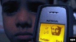 Still a fan? A young Pakistani boy with an image of Al-Qaeda leader Osama bin Laden on his mobile phone in Karachi in 2003.