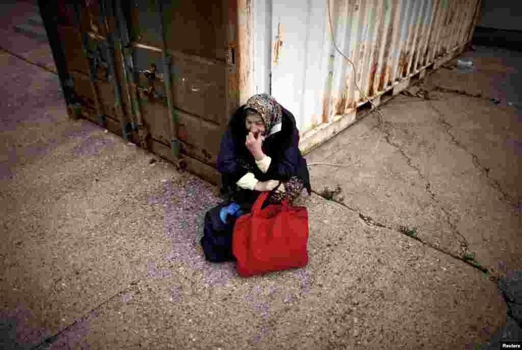 A woman waits for food in front of a soup kitchen. Some 600 residents depend on the public kitchens for their daily meals. 