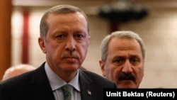 Recep Tayyip Erdogan (L) arrives for a news conference as he is flanked by former Economy Minister Zafer Caglayan. File photo 2013