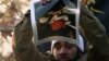 Iran -- A protester tears a picture of British Queen Elizabeth II which took it from the inside the British embassy in Tehran, 29Nov2011