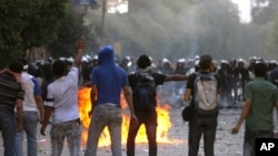 Demonstrators throw stones at Egyptian security forces close to the Interior Ministry in Cairo today.