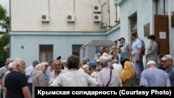 Rusiye kontrolindeki Qırım ükümetiniñ binası ögünde semetdeşlerniñ taqip etilüvine qarşı çıqqan qırımtatarlarnıñ mitingi. Aqmescit, 2020 senesi iyülniñ 8-i