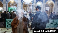 Smoking Syrian Rue, a plant believed to cure sickness in Masoumeh Shrine in Qom on February 25, 2020