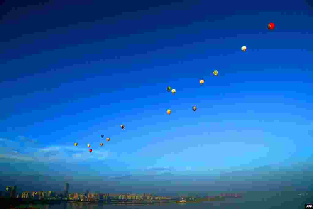 Hot-air balloons fly across Qiongzhou Strait in Haikou in south China&#39;s Hainan Province during the H1 China Hot Air Balloon Challenge. Fifteen balloons flew over the strait in 2.5 hours and succeeded in landing on Leizhou Peninsula in Hai&#39;an. (AFP)