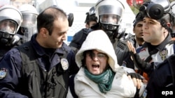 Turkish police detain a female protester outside of the Water Forum.