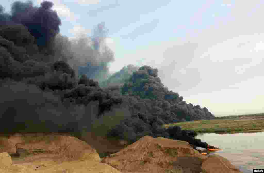 A cloud of smoke rises from an oil pipeline in Tikrit, north of Baghdad. (Reuters)