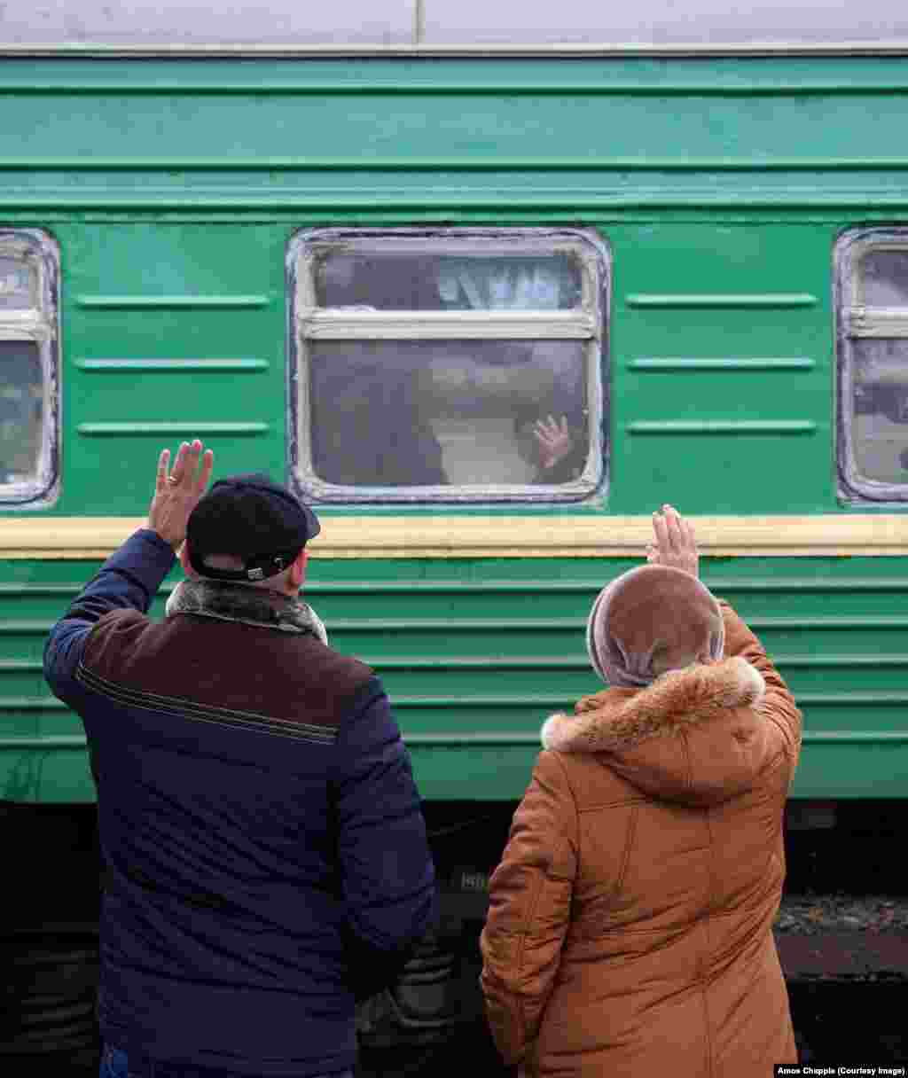 People wave goodbye to a friend from a station in southern Russia. A platzkart bed for an overnight Moscow-St. Petersburg trip sells for around $20 &ndash; less than most hotels.