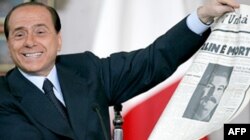 Сильвіо Берлусконі з газетою із портретом Сталіна