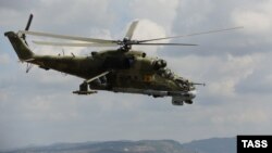 A Mil Mi-24 combat helicopter flies over the Hmeimim air base in syria.