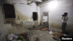 A member of the media takes a photograph inside the basement of the Zakariya madrasah on December 13.