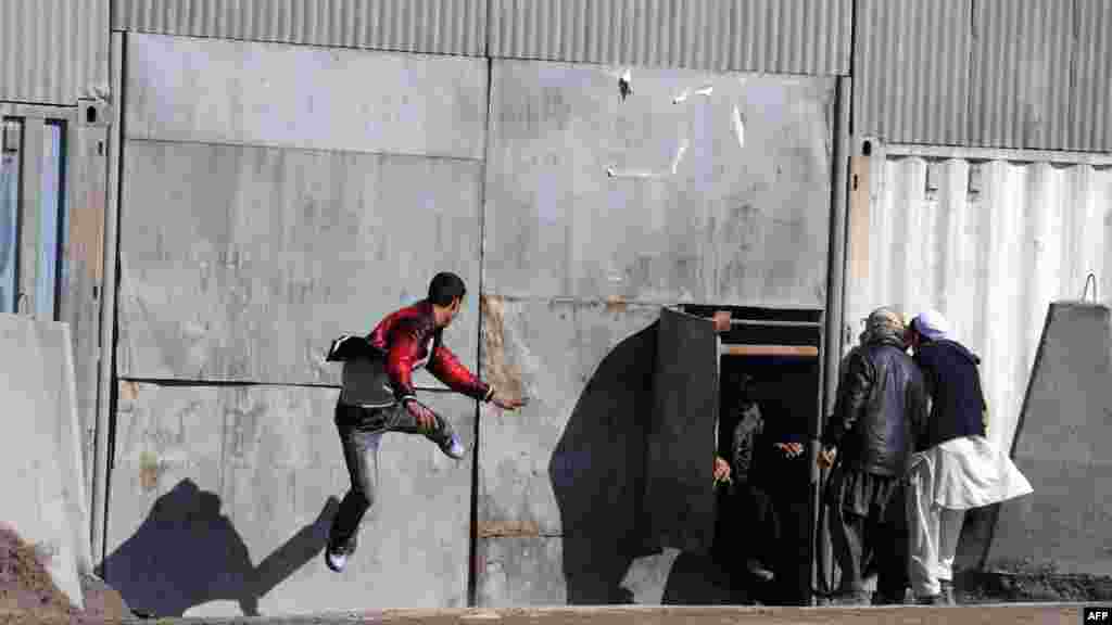 An Afghan protester kicks the gate to an international army base gate during a protest against Koran desecrations in Kabul on February 22. (AFP PHOTO/SHAH Marai)