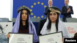 Nadia Murad Basee (left) and Lamiya Aji Bashar pose with the 2016 Sakharov Prize during an award ceremony at the European Parliament in Strasbourg, France, on December 13.