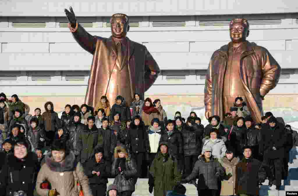 People visit in front of bronze statues of North Korea founder Kim Il Sung (left) and late leader Kim Jong Il in Pyongyang. (Reuters/Kyodo)