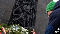 К памятнику героям восстания в гетто в Варшаве возлагают нарциссы. 19 апреля 2015 года.