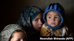 Afghan children warm themselves at a refugee camp on the outskirts of Laghman. (file photo)