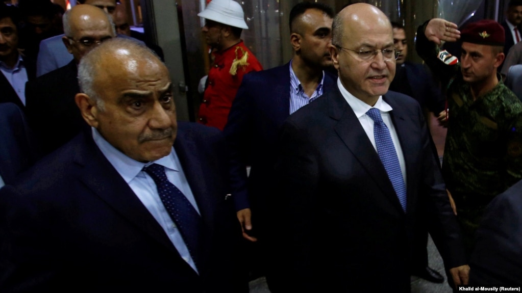 Barham Salih (right), Iraq's newly elected president, walks with new Prime Minister Adel Abdul-Mahdi at the parliament in Baghdad on October 2.