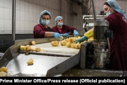 Tri punëtore duke punuar në fabrikën e Vipa Chips. Fotografi nga arkivi.