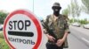 A pro-Russian militant stands guard at a checkpoint on the road from Donetsk to Mariupol.