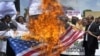 Участники акции протеста против намерения устроить акцию по сожжению Корана в США сжигают американский флаг. Пакистан, 9 сентября 2010 года. 