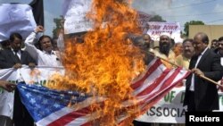 Участники акции протеста против намерения устроить акцию по сожжению Корана в США сжигают американский флаг. Пакистан, 9 сентября 2010 года. 