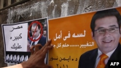 An Egyptian puts up campaign posters ahead of this year's presidential election.