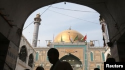 Pakistan -- Devotees are silhouetted as they gather at the tomb of Sufi saint Syed Usman Marwandi, also known as the Lal Shahbaz Qalandar shrine, after Thursday's suicide blast, in Sehwan Sharif, Pakistan's southern Sindh province, February 17, 2017.