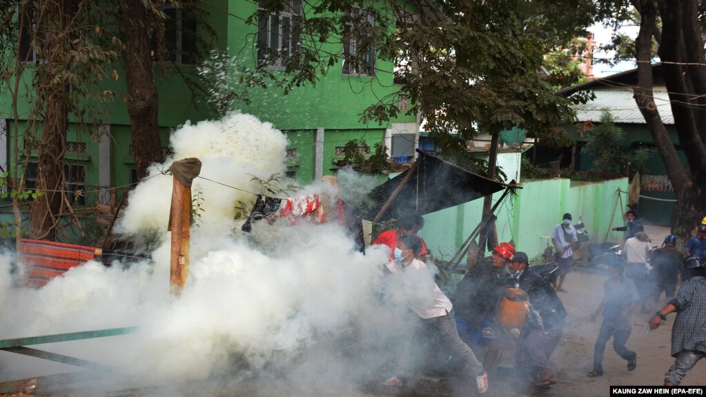 صحنه‌ای از درگیری مردم معترض با پلیس میانمار پس از استفاده از گاز اشک‌آور توسط نیروهای امنیتی