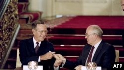 US President George Bush (L) and Soviet leader Mikhail Gorbachev exchange pens after signing the historic Strategic Arms Reduction Treaty (START) to cut the superpowers's nuclear arsenals by up to a third in Moscow, July 31, 1990