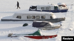 A man passes by snow-covered boats during the current cold spell in Kyiv. 