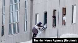 Iran -- A woman is evacuated during an attack on the Iranian parliament in central Tehran, June 7, 2017