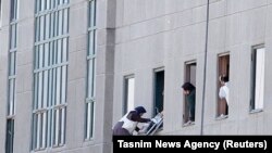 A woman is evacuated during the attack on the Iranian parliament in central Tehran on June 7.