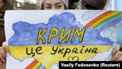 Девушка с плакатом с надписью на украинском языке: «Крым – это Украина» – во время акции в Симферополе против агрессии России, незадолго до аннексии полуострова. 10 марта 2014 года.