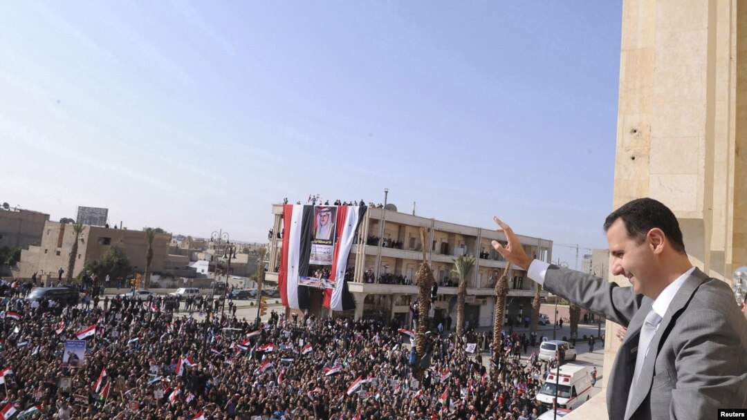 Syrian President Bashar al-Assad greets the crowd during a visit to Raqqa on November 6.