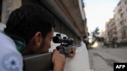 Syria -- A fighter from the Syrian opposition aims fire during clashes with forces loyal to President Bashar al-Assad, in the center of Syria's restive northern city of Aleppo, 25Jul2012.