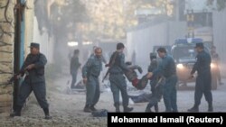 Полиция уносит раненого в результате взрыва в Кабуле, 31 октября 2017