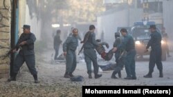 Afghan police carry away a victim after a blast in a diplomatic zone of Kabul on October 31.