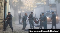 Afghan police carry away a victim after a blast in a diplomatic zone of Kabul on October 31.