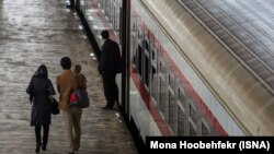 Iran -- An Iranian family walking in a rail station, undated.