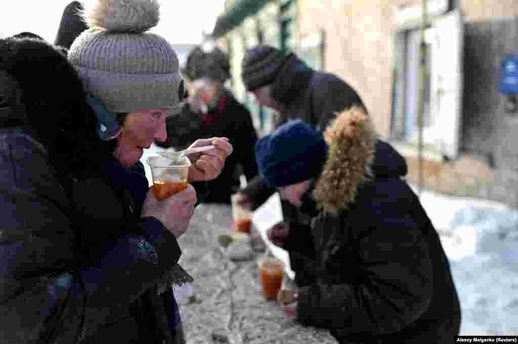 Lyuda eats a hot meal at a soup kitchen run by volunteers.