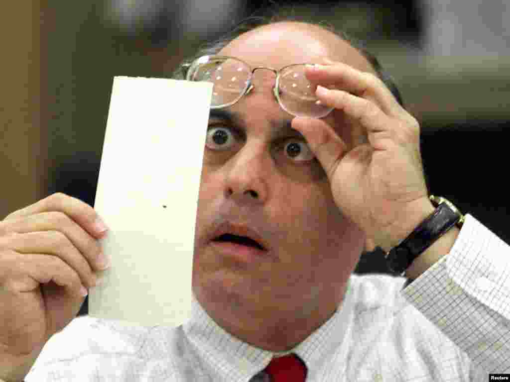 Broward County Canvassing Board member, Judge Robert Rosenberg, stares at a dimpled punchcard ballot November 23, 2000 as the board begins counting the county's ballots that were considered questionable. After review by the three member panel, the vote went to Republican presidential candidate George W. Bush. Gore is in the final stages of a legal challenge to wrest the presidency away from Bush. REUTERS