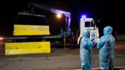 Алматы қаласына кіреберіс жолда тұрған арнаулы киім киген адамдар.