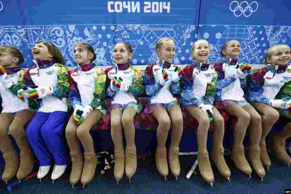 Девочки, которые собирают со льда цветы после выступлений спортсменов в фигурном катании